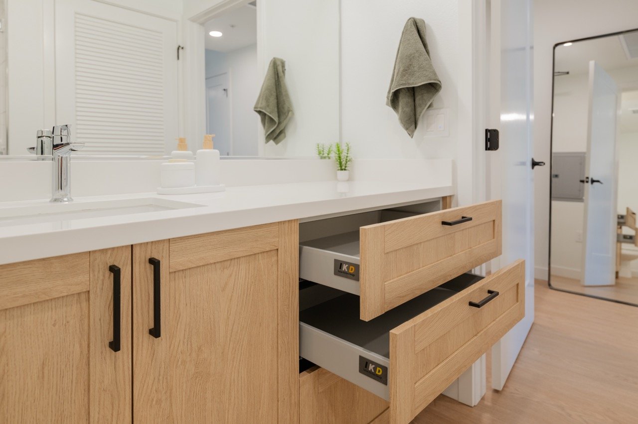 White oak bathroom vanity with a quartz top and full-width mirror