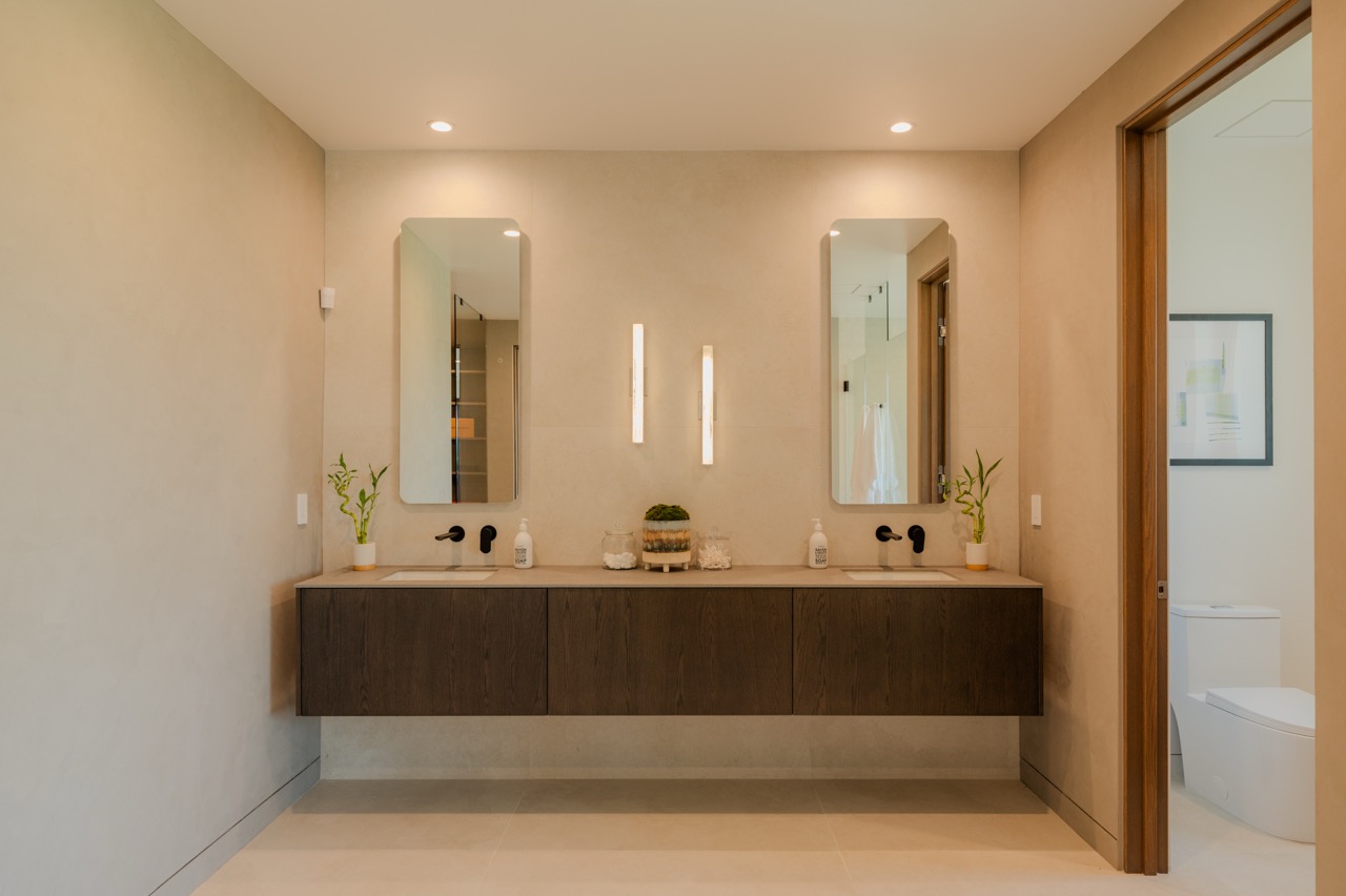Symmetrical double vanity in dark oak with twin mirrors and integrated under-cabinet lighting