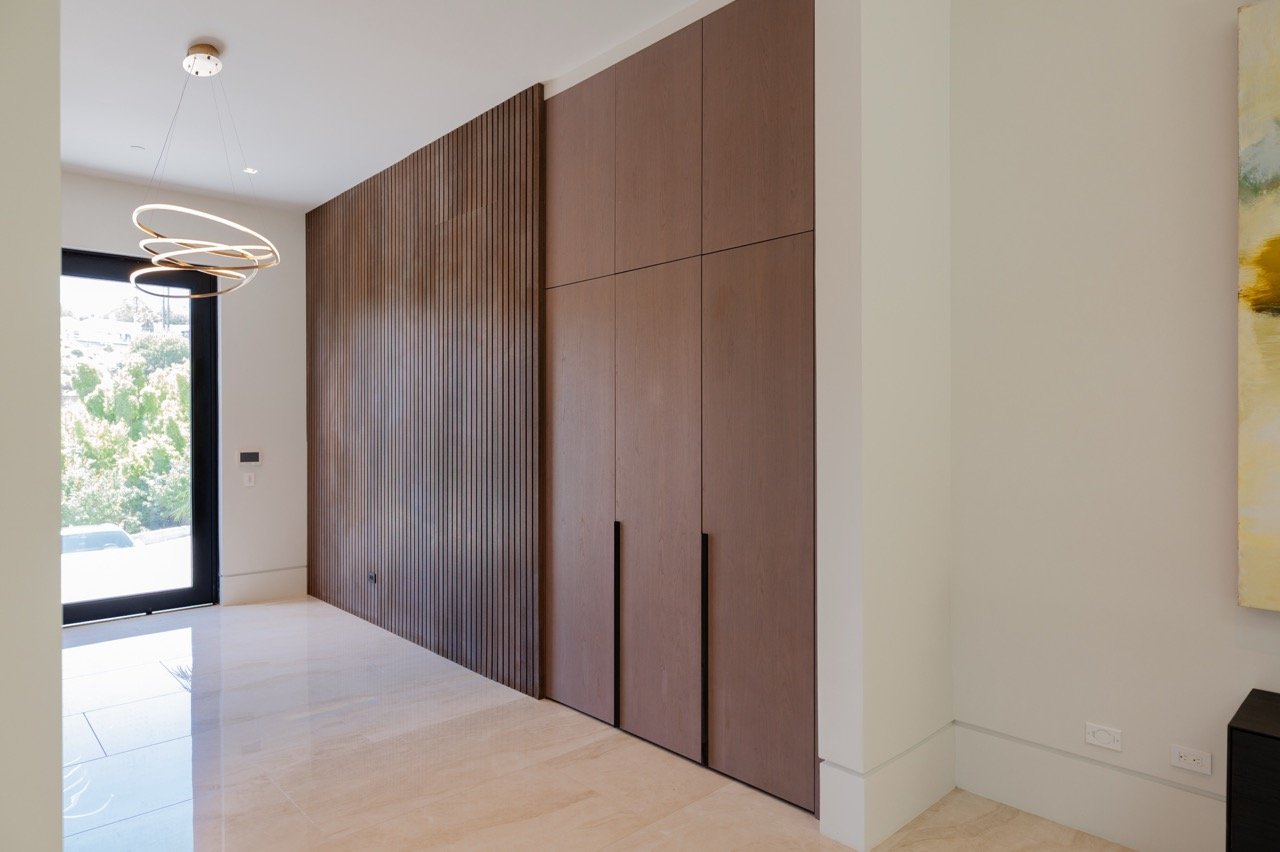 Entry wardrobe in walnut set against a matching slatted wall