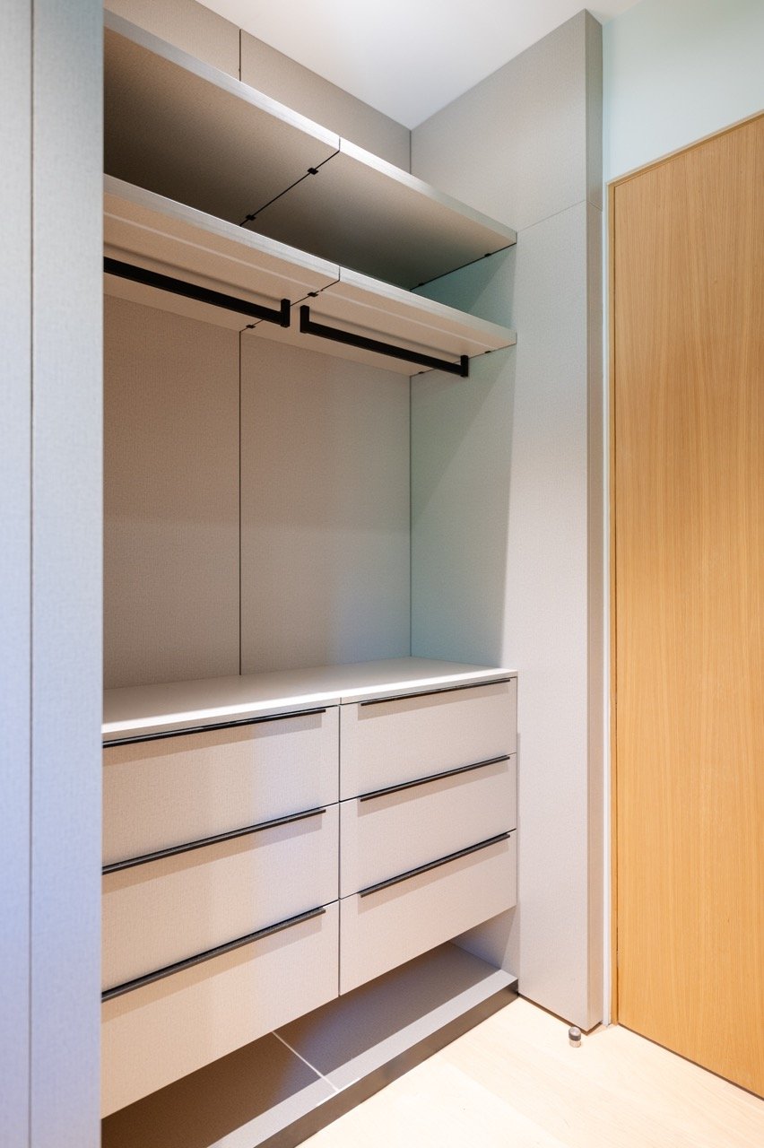 Reach-in closet with a six-drawer bank, upper shelving and a full-width rail
