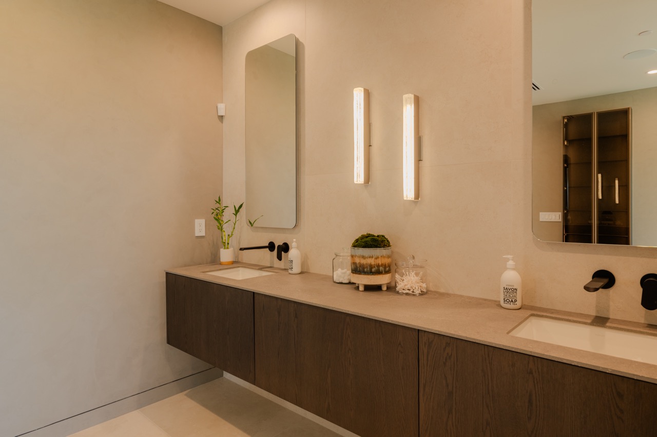 Primary bathroom with a floating oak vanity, freestanding tub, and glass shower enclosure