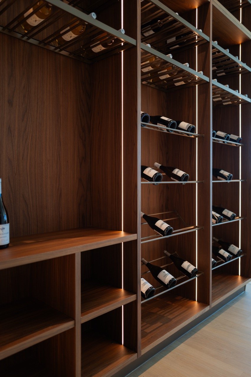Walnut racking detail — steel cradles, LED strips and a serving ledge