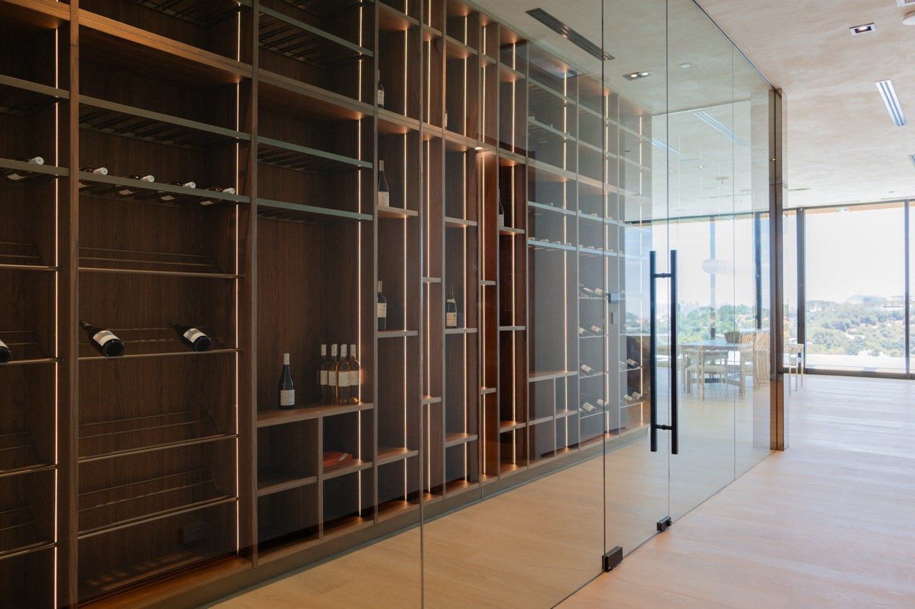 Climate room behind full-height glass, with walnut racking lit from within