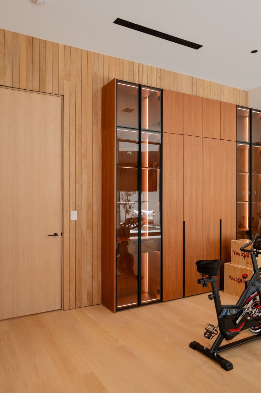 Lit glass vitrines set into a run of full-height cabinetry