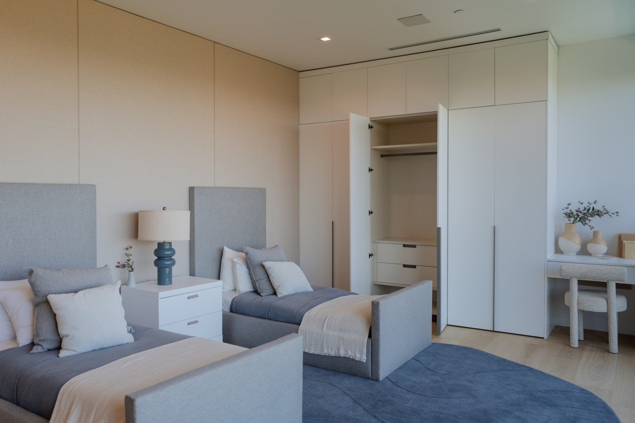 Fitted bedroom wardrobe opened to a hanging section and interior drawers