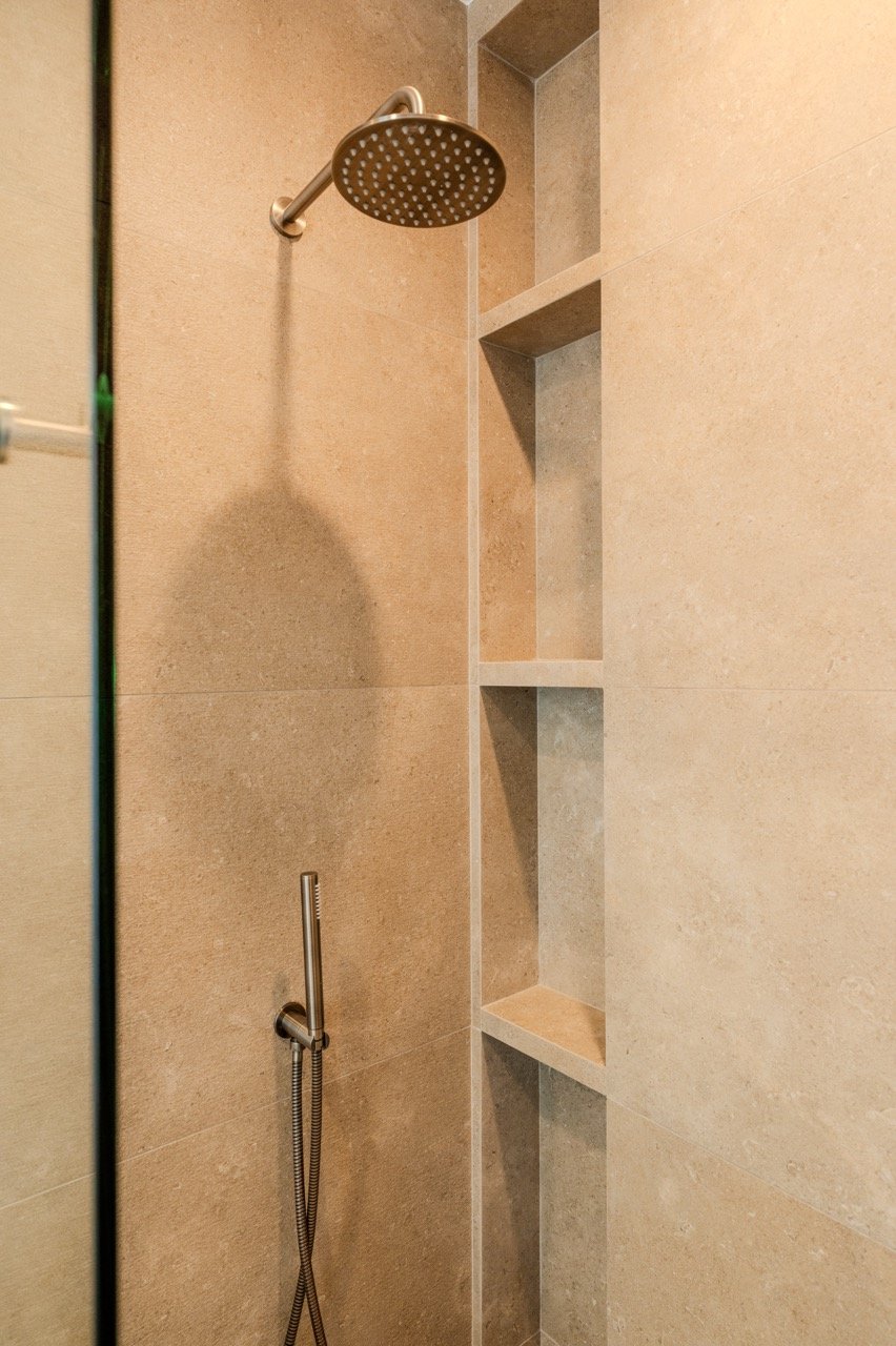 White oak European cabinetry with concealed hinges and a herringbone tile backsplash