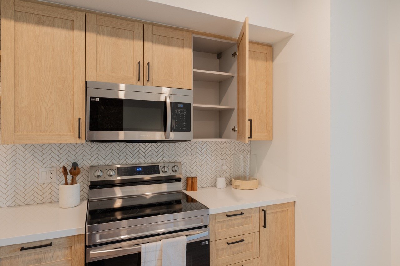 Two full-extension soft-close drawers pulled open on a white oak bathroom vanity, showing steel drawer boxes